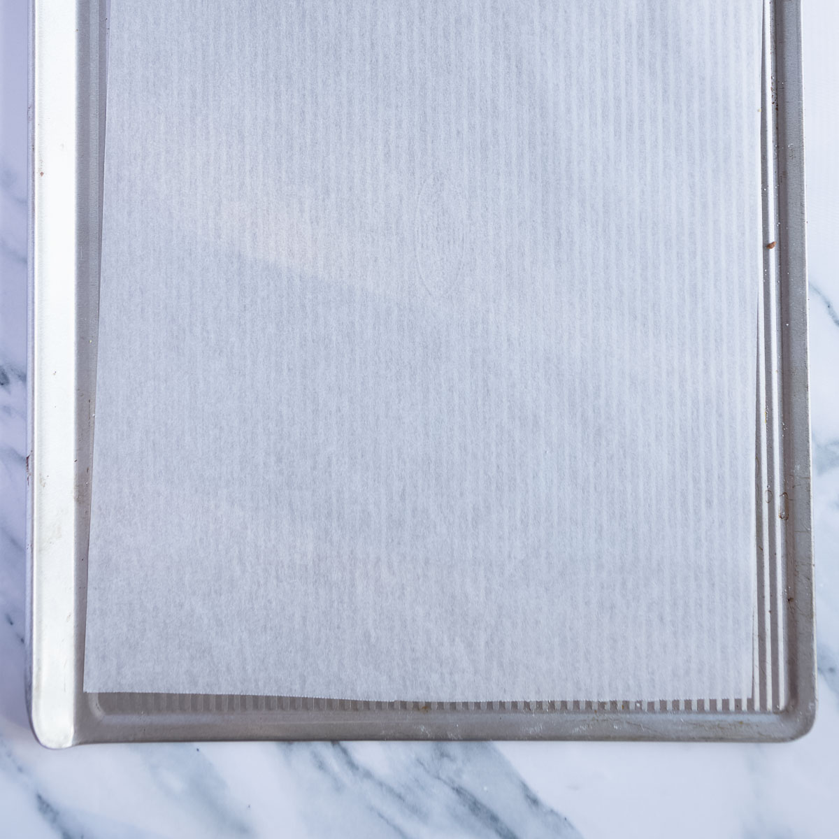 Lining a large baking sheet with baking paper.