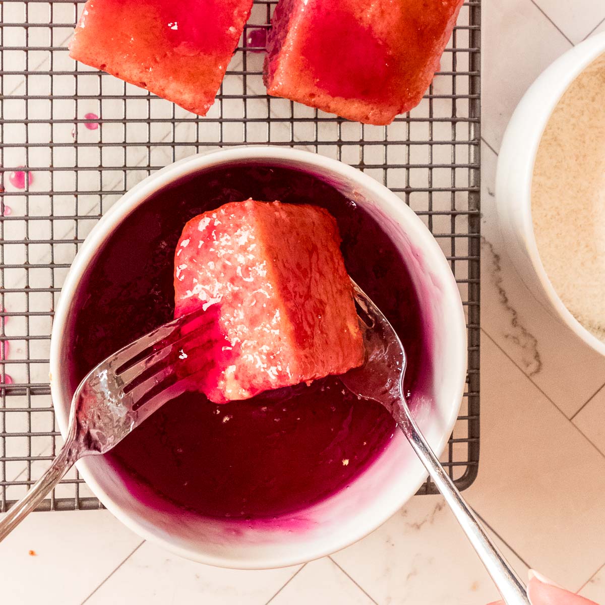 Rolling the butter cake squares in the raspberry jelly.