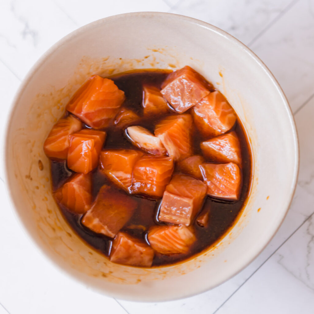 Marinating cubes of salmon for the salmon bowls.