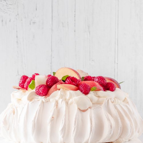 decorated pavlova, topped with fresh fruit