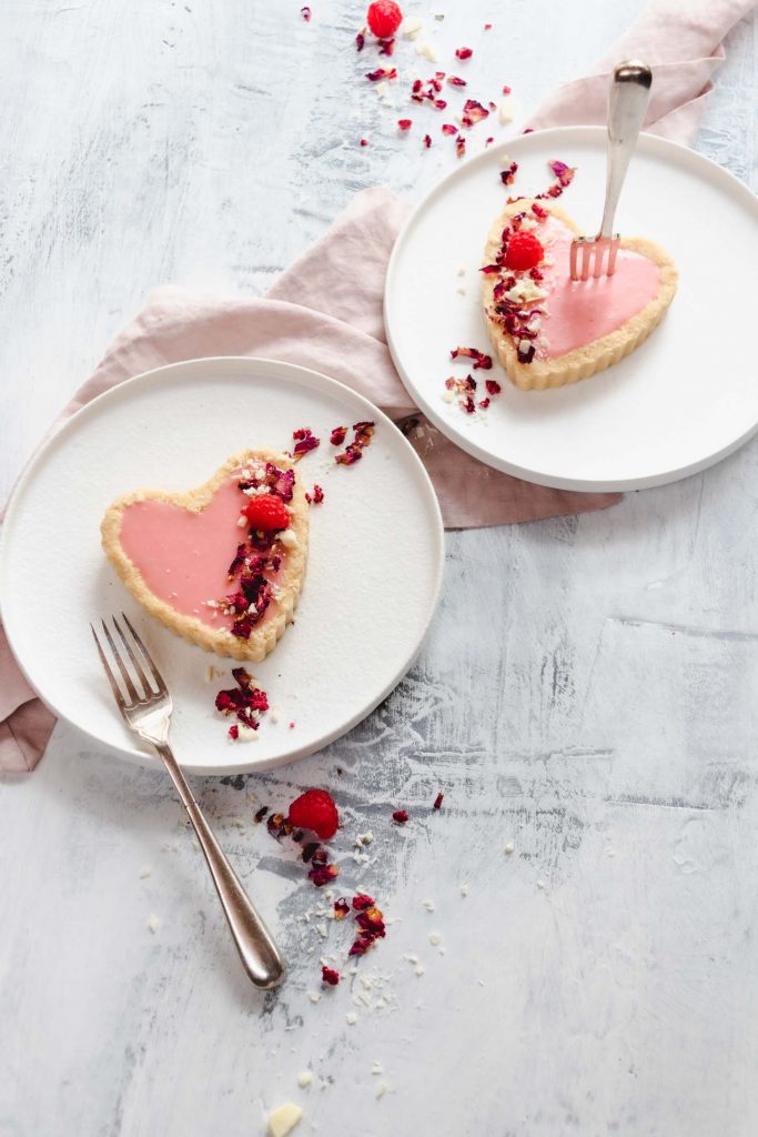 two pink chocolate tarts on white plates