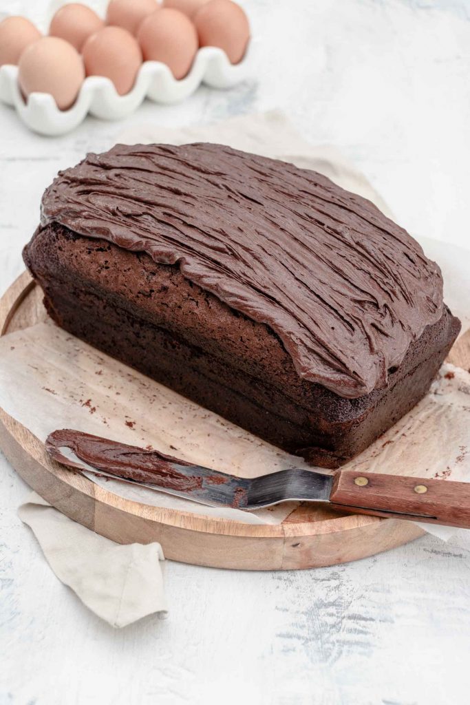 frosting a chocolate cake with an offset spatula