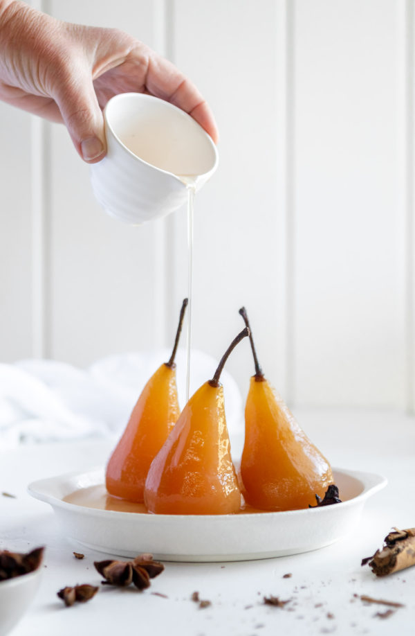 pouring syrup over poached pears