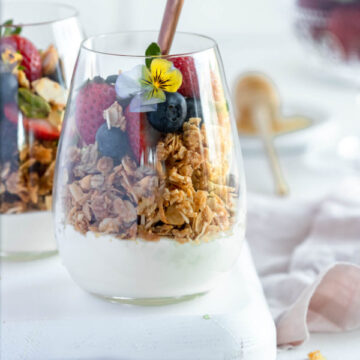Breakfast parfait, made with vanilla bean panna cotta, honey baked granola, fresh berries and edible flowers