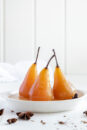 Three beautiful pears in poaching liquid.