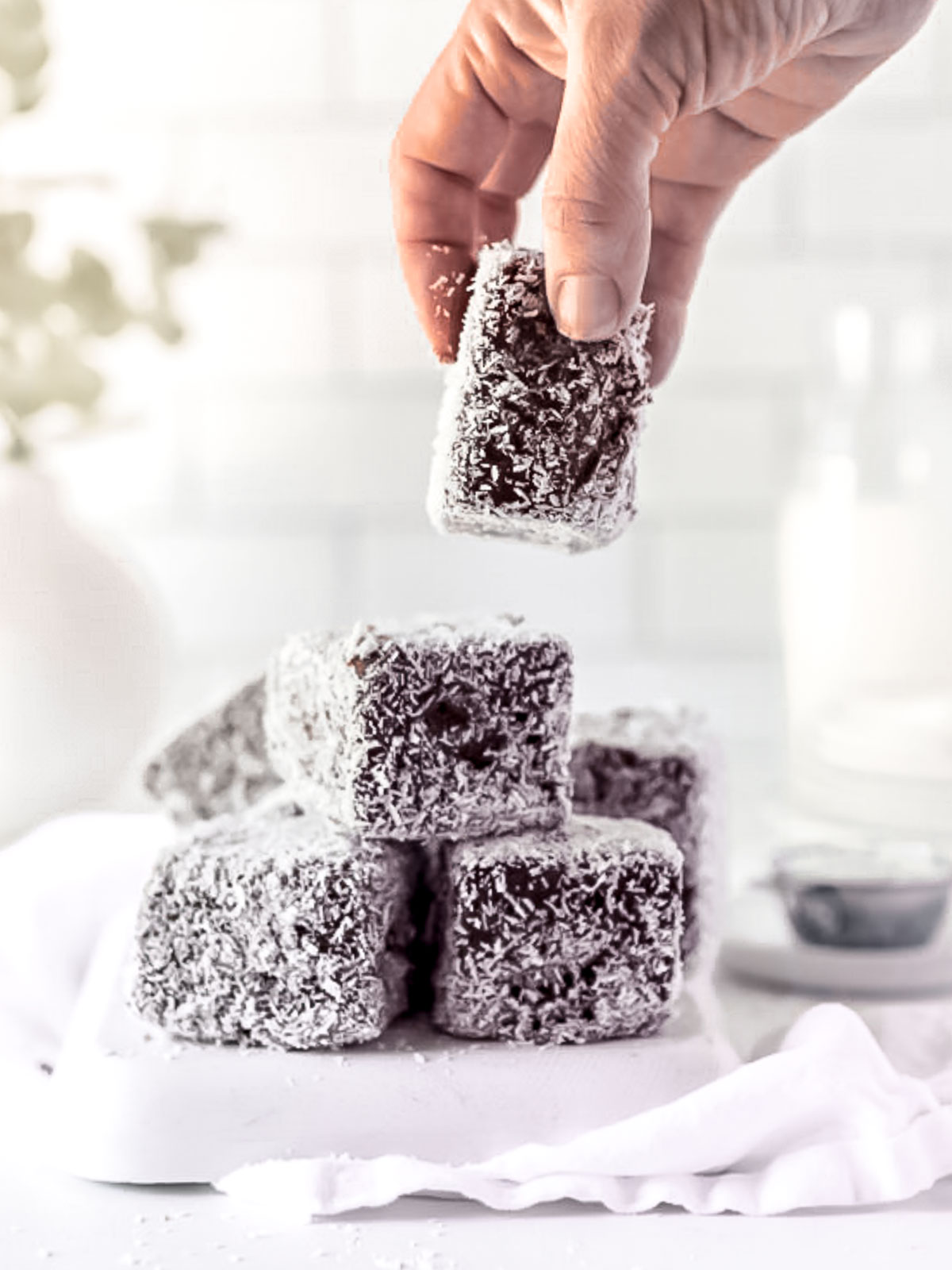 A plate of classic lamingtons, coated in chocolate and coconut.