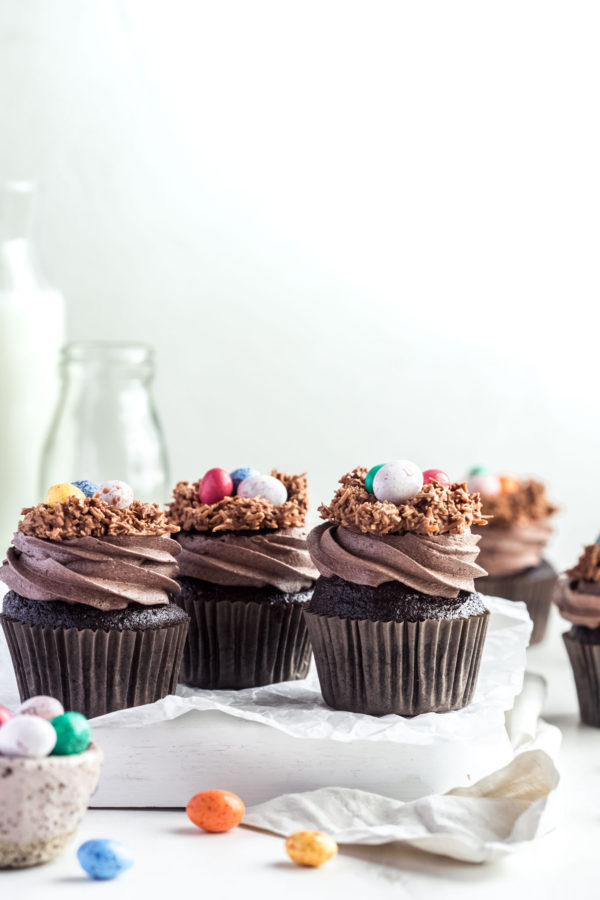 chocolate cupcakes with swirls chocolate frosting topped with easter eggs