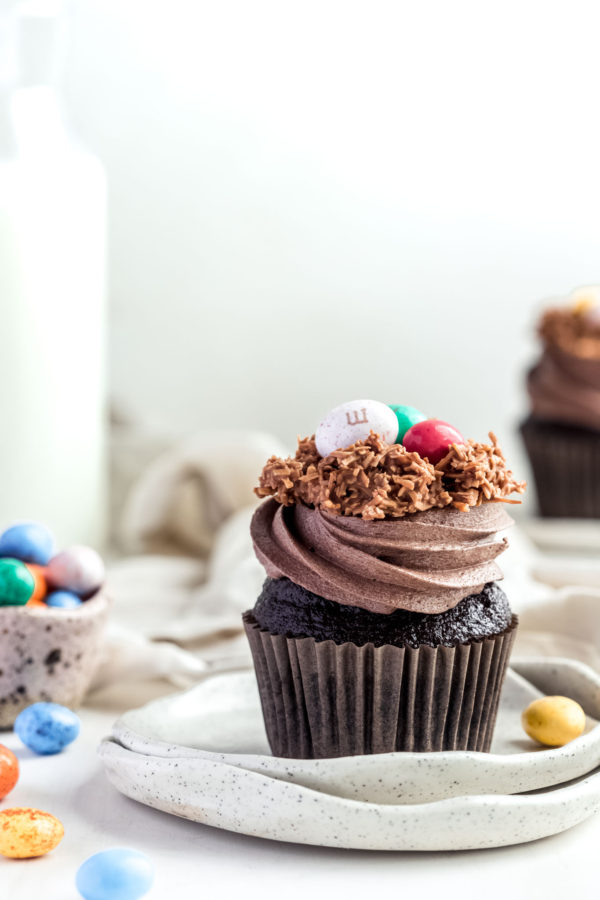 single chocolate cupcake with swirls chocolate frosting topped with easter eggs
