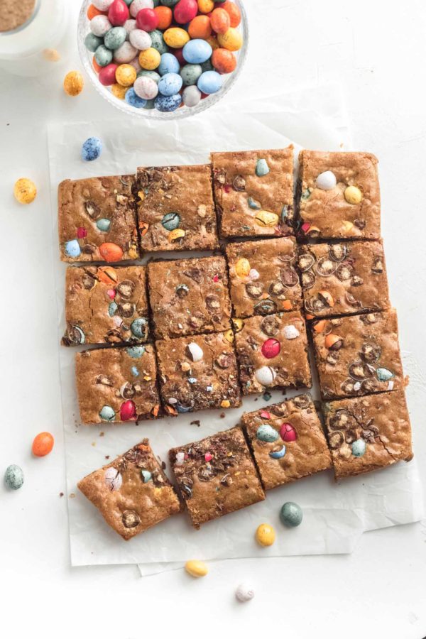 16 Easter egg blondies with a bowl of M&M speckled eggs