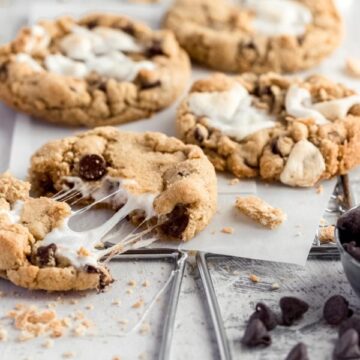 s'mores cookie on a tray, with one cookie being pulled apart to show the gooey marshmallow