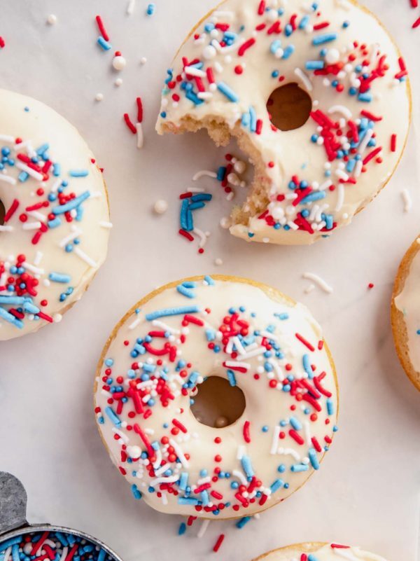 overhead shot of glazed donuts with a bite out of one