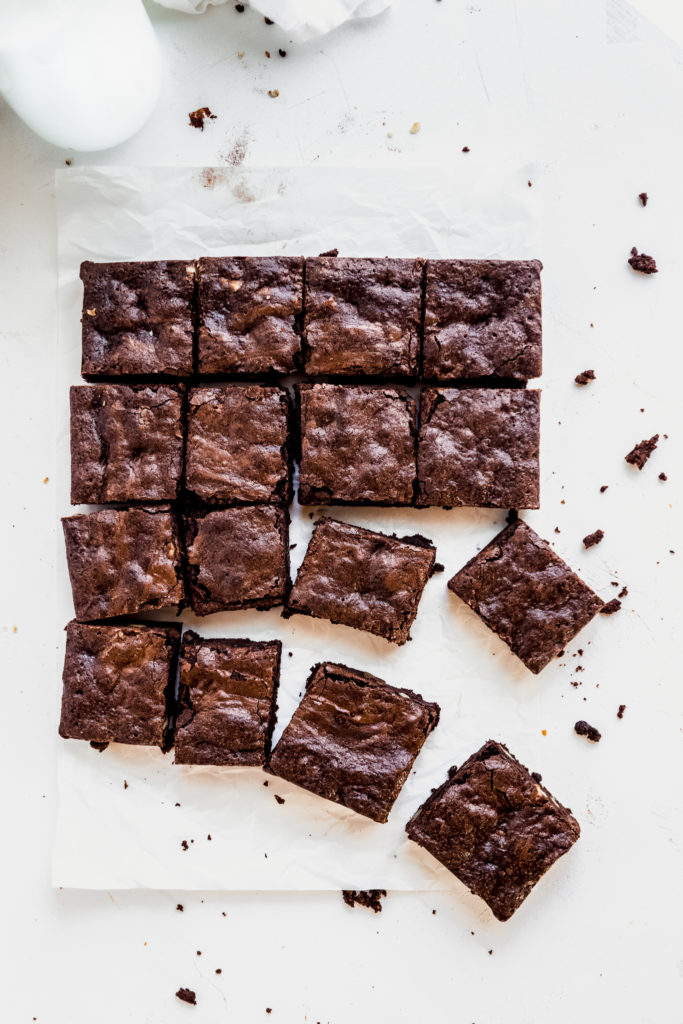 16 brownie squares on a sheet of baking paper