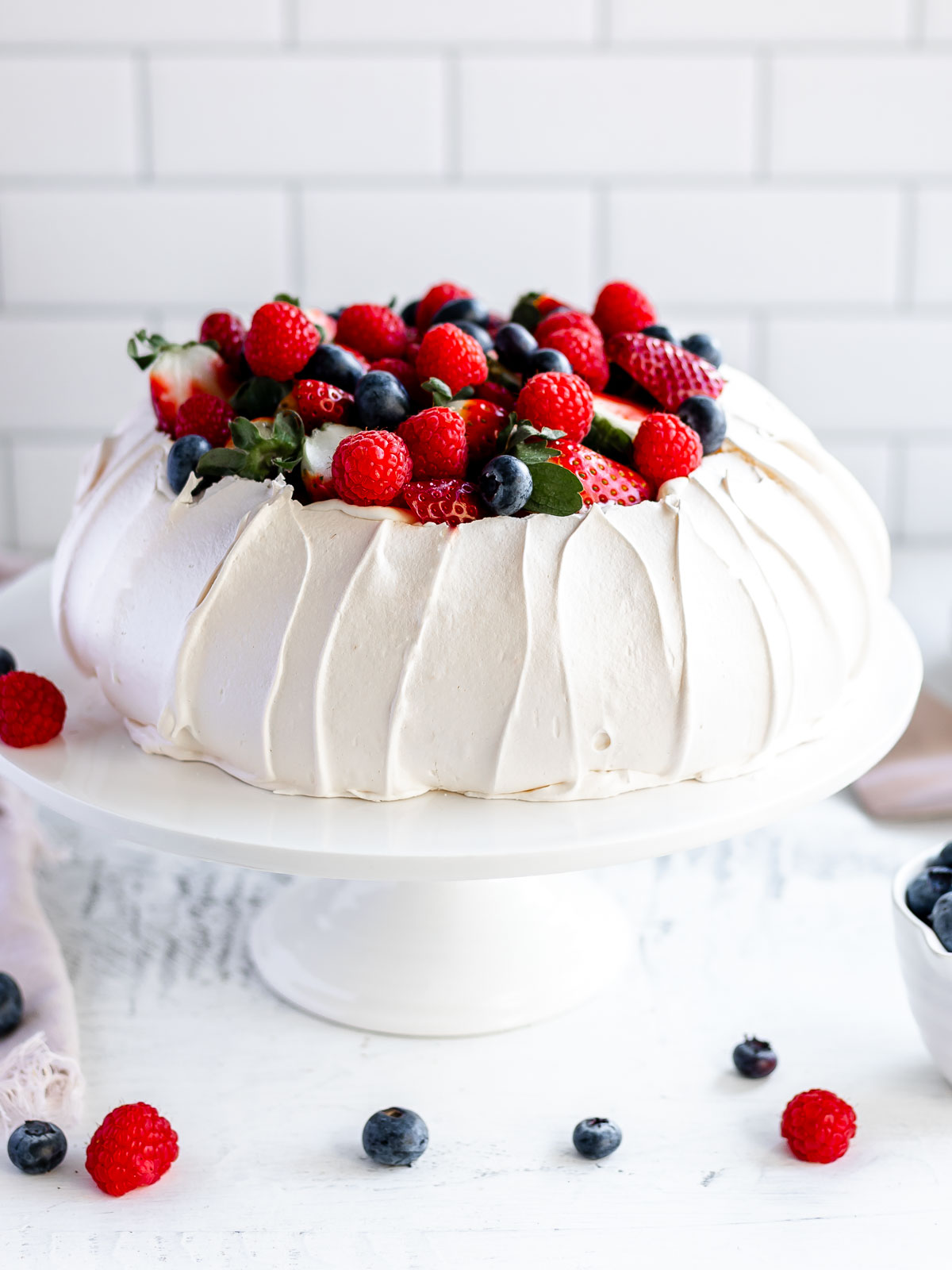 How to make a perfect pavlova, with a crisp shell and marshmallow centre, topped with cream and berries.