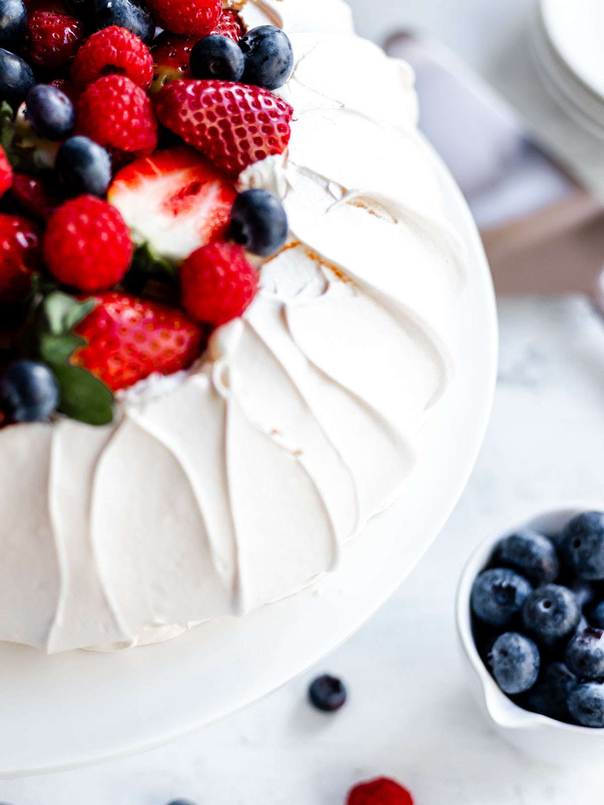 How to make a perfect pavlova, with a crisp shell and marshmallow centre, topped with cream and berries.