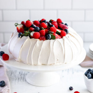 How to make a perfect pavlova, with a crisp shell and marshmallow centre, topped with cream and berries.