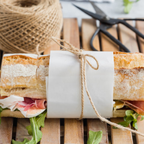 baguette sandwich wrapped in paper and tied with string