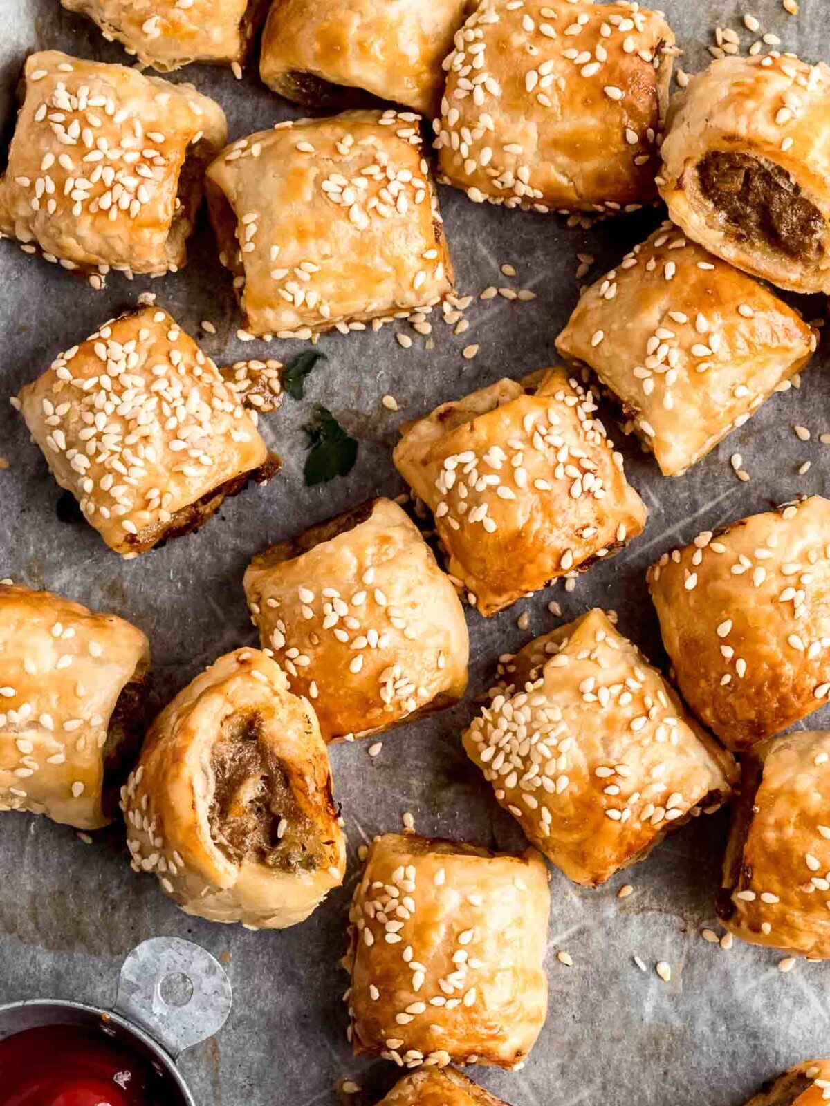 Close up of easy homemade sausage rolls with on a tray with tomato sauce.