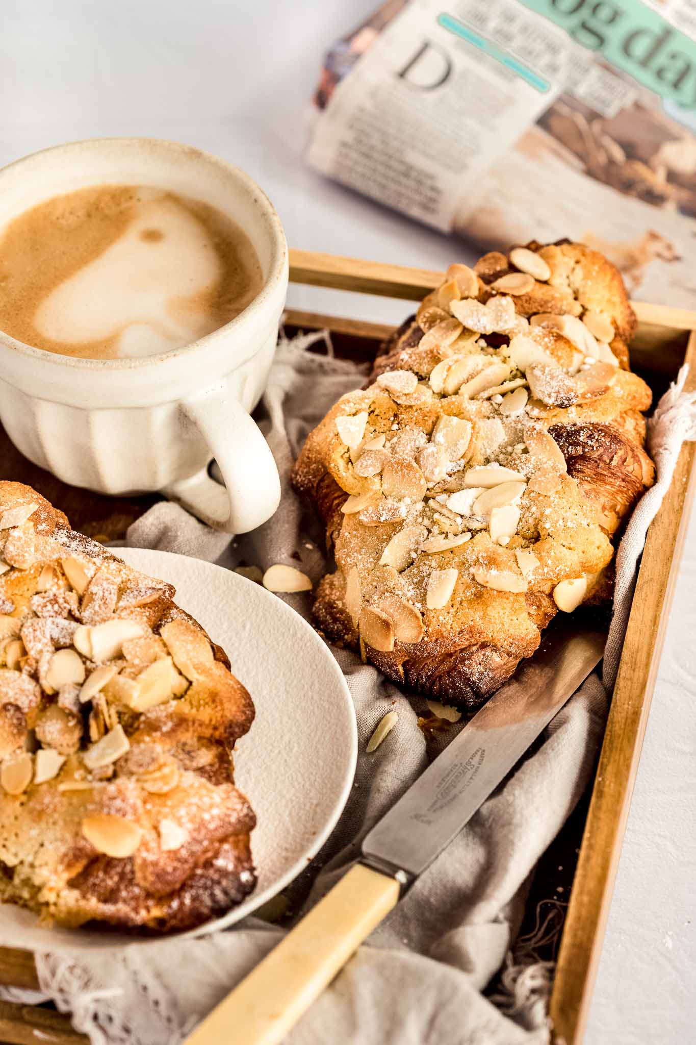 tray with 2 almond croissants and a coffee