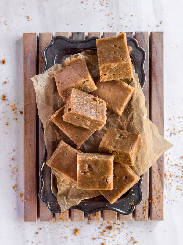 overhead shot of squares of no bake caramel slice on a vintage tray