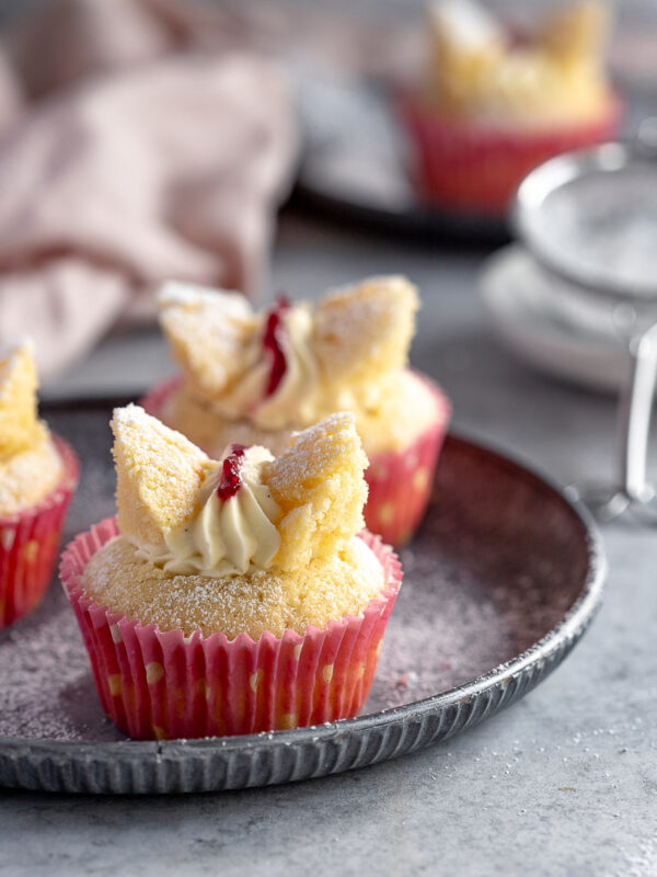 2 butterfly cupcakes on a vintage tray