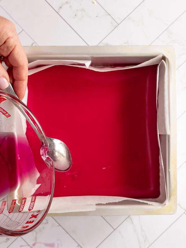 pouring jelly layer onto the set condensed milk layer