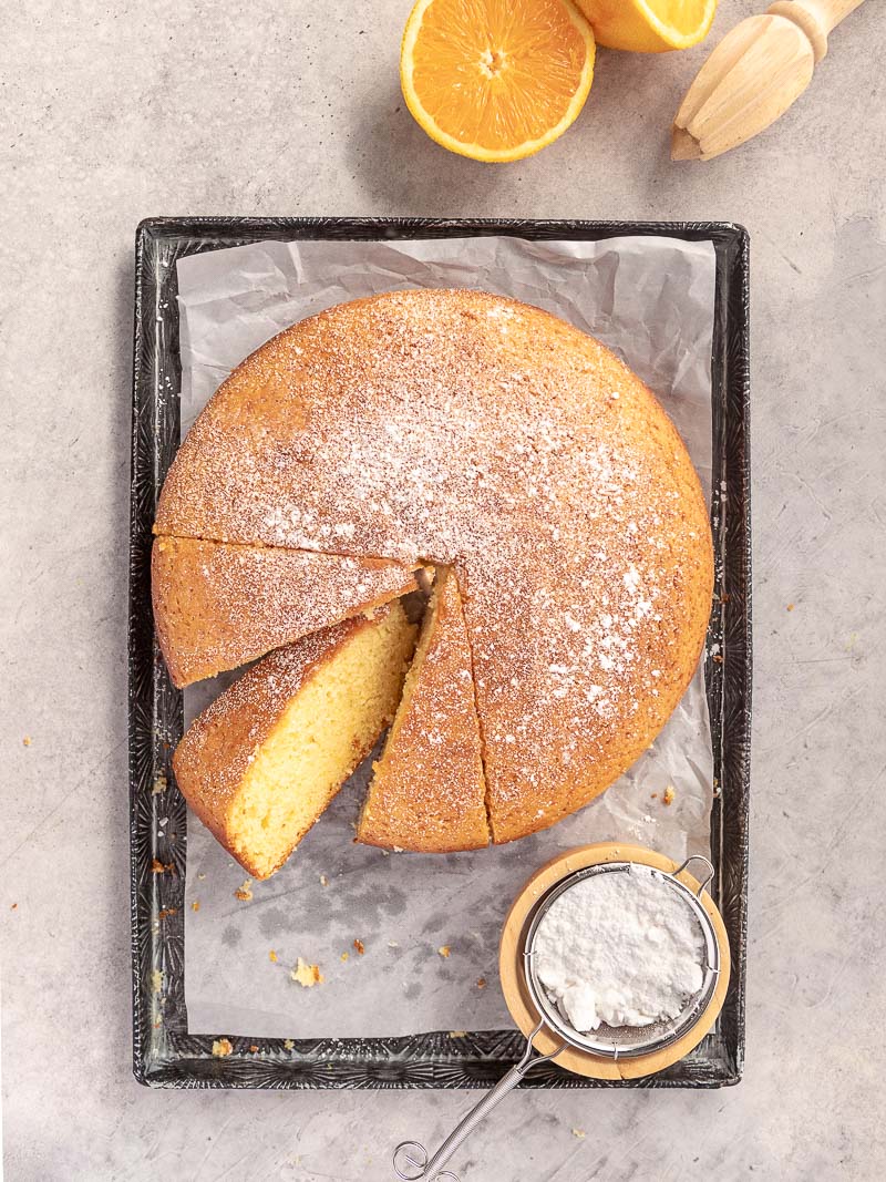 A tender and moist homemade orange cake, cut into wedges.