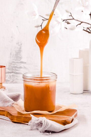 Spooning homemade salted caramel out of a jar.