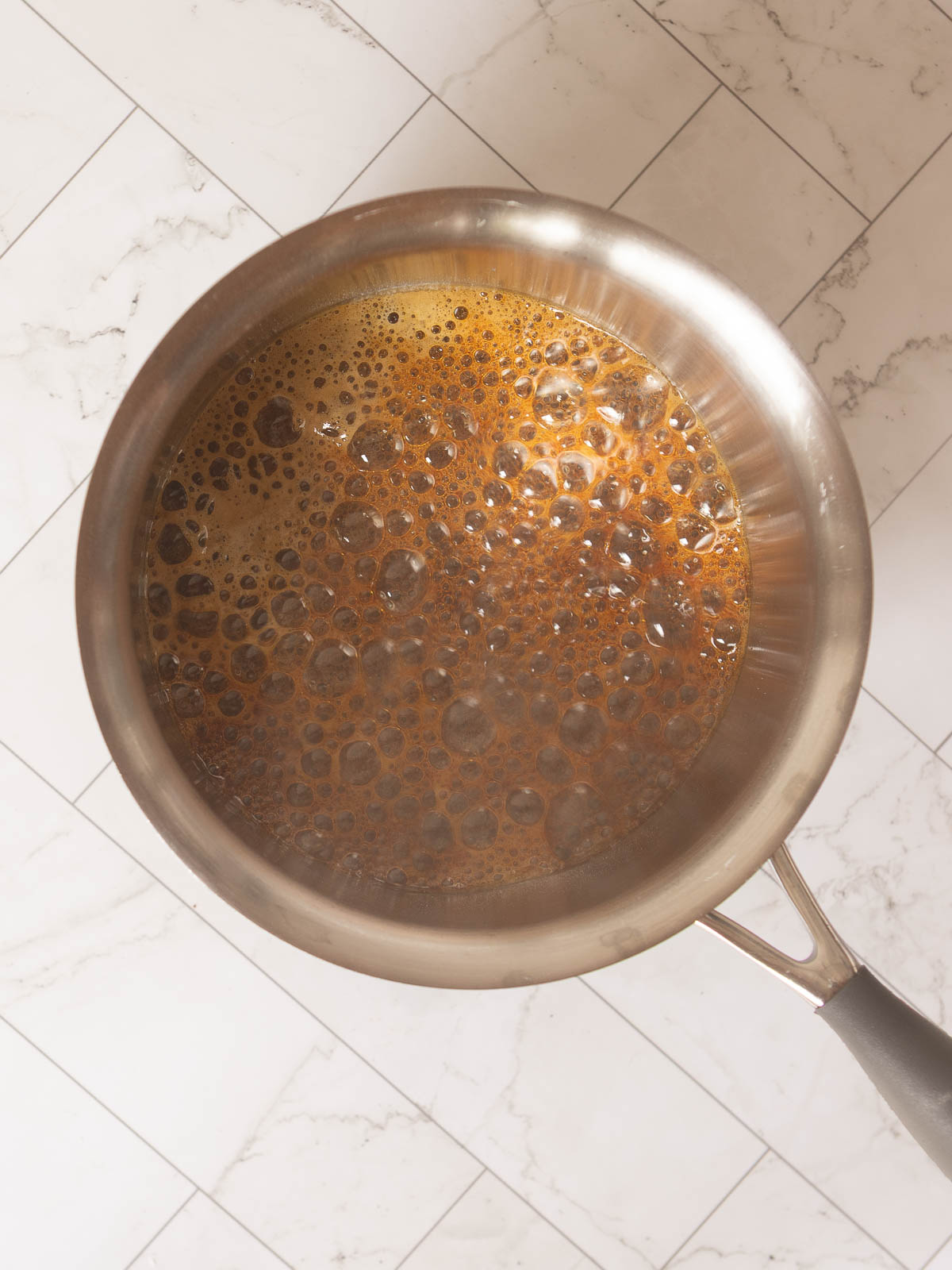 Boiling sugar and water to make a caramel.