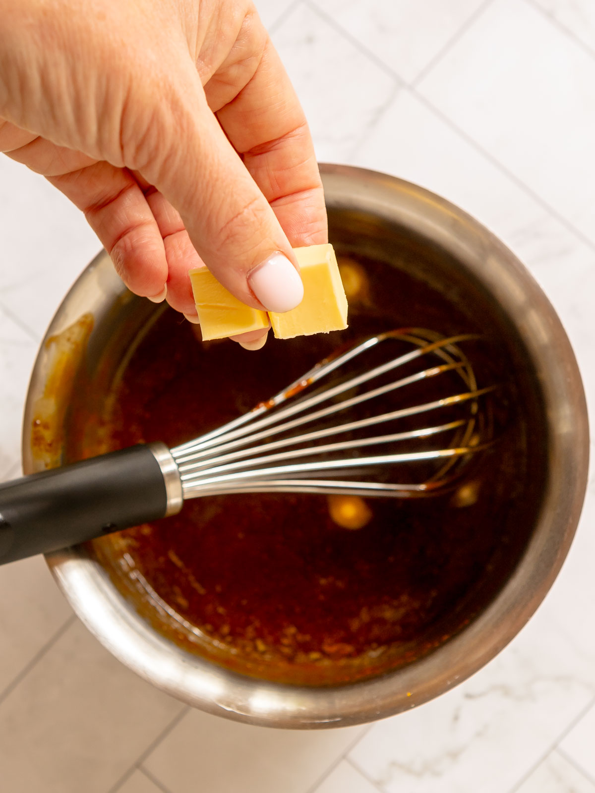 Add the butter 2 cubes at a time, then whisk until smooth.