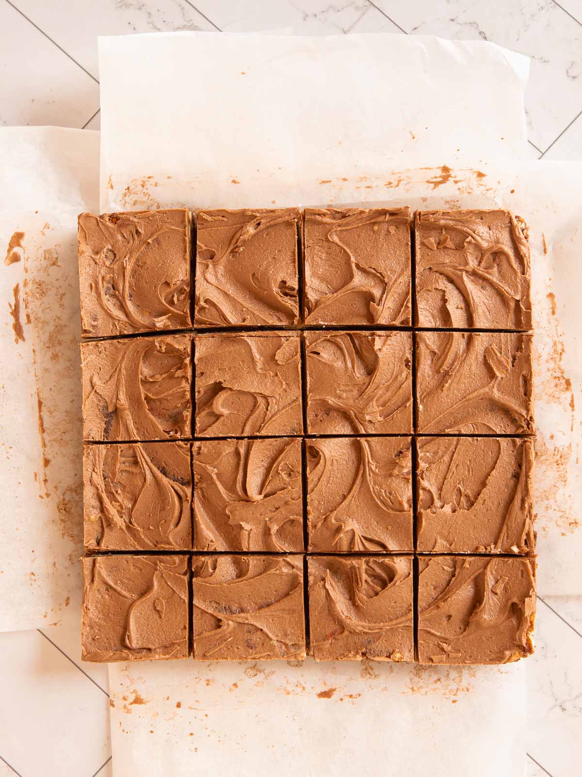 Covering hedgehog slice with frosting, then cutting into squares.