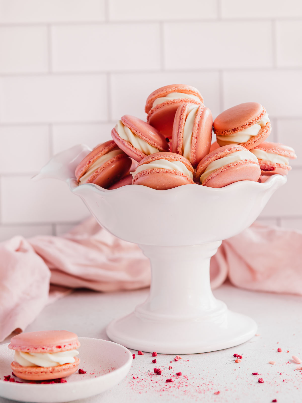 A bowl full of pink macarons