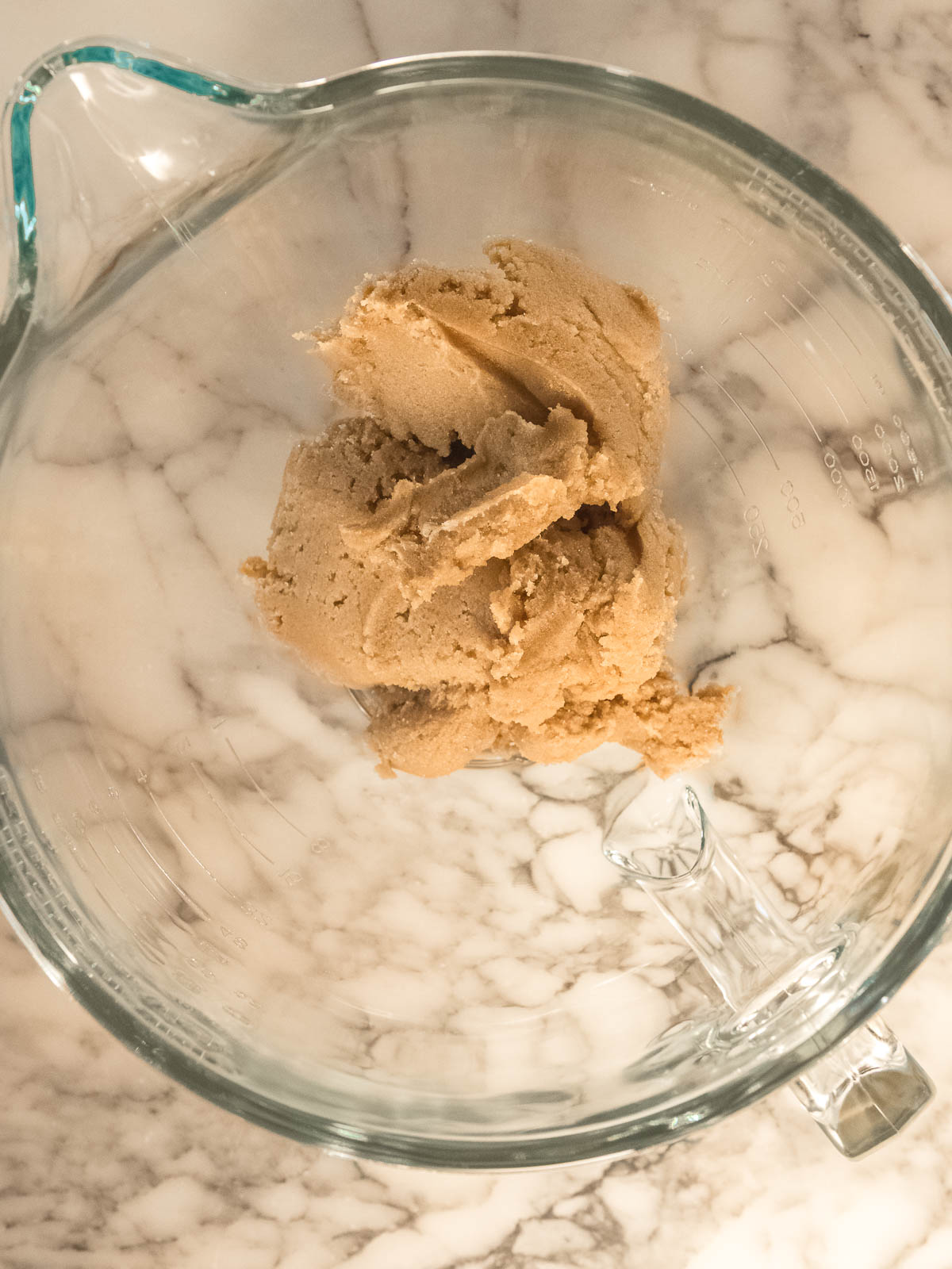Creaming butter with white and brown sugar in a mixing bowl for chocolate marshmallow cookie dough – easy chewy chocolate cookie base recipe.
