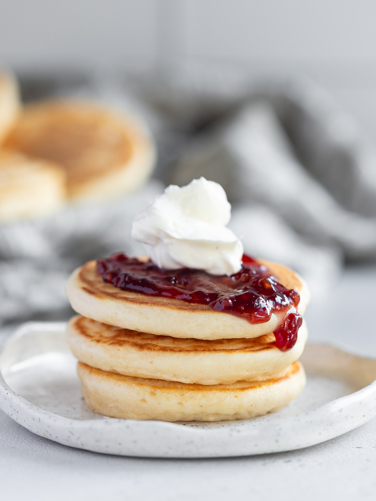 Pikelets topped with raspberry jam and chantilly cream.