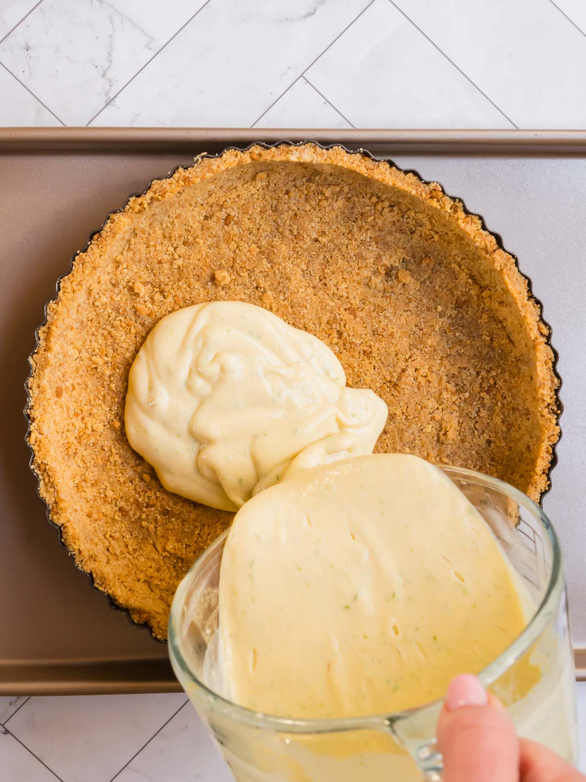 Pouring the creamy lime filling into the gluten-free pie crust.