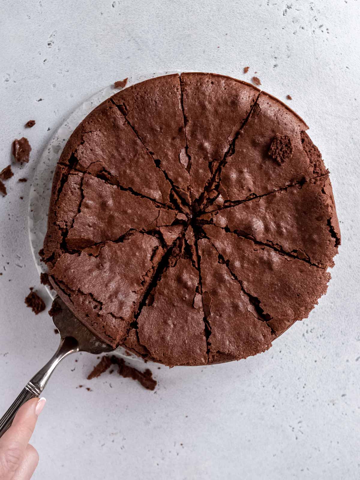 A whole chocolate fudge cake that has been cut into serving sizes