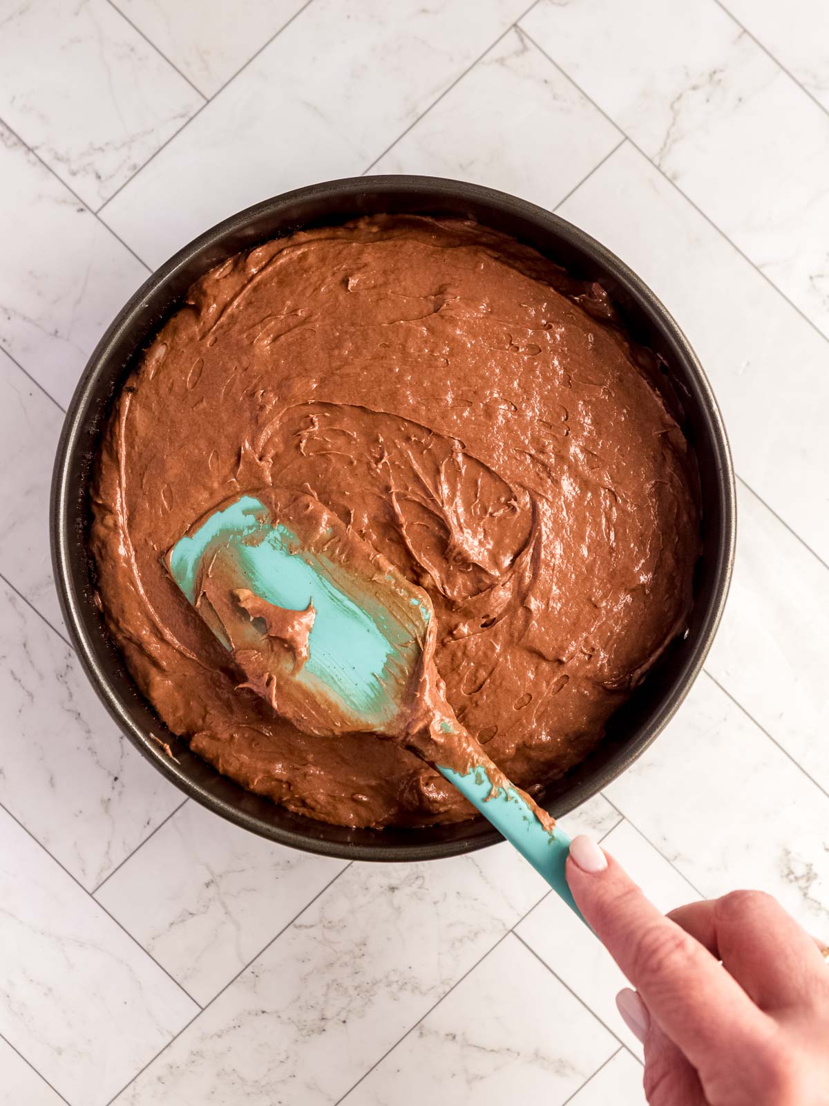 Spreading the chocolate and banana cheesecake filling into the baked shell
