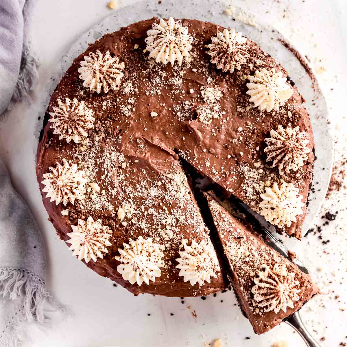 A large banana and chocolate cheesecake, with chantilly cream piped on top.