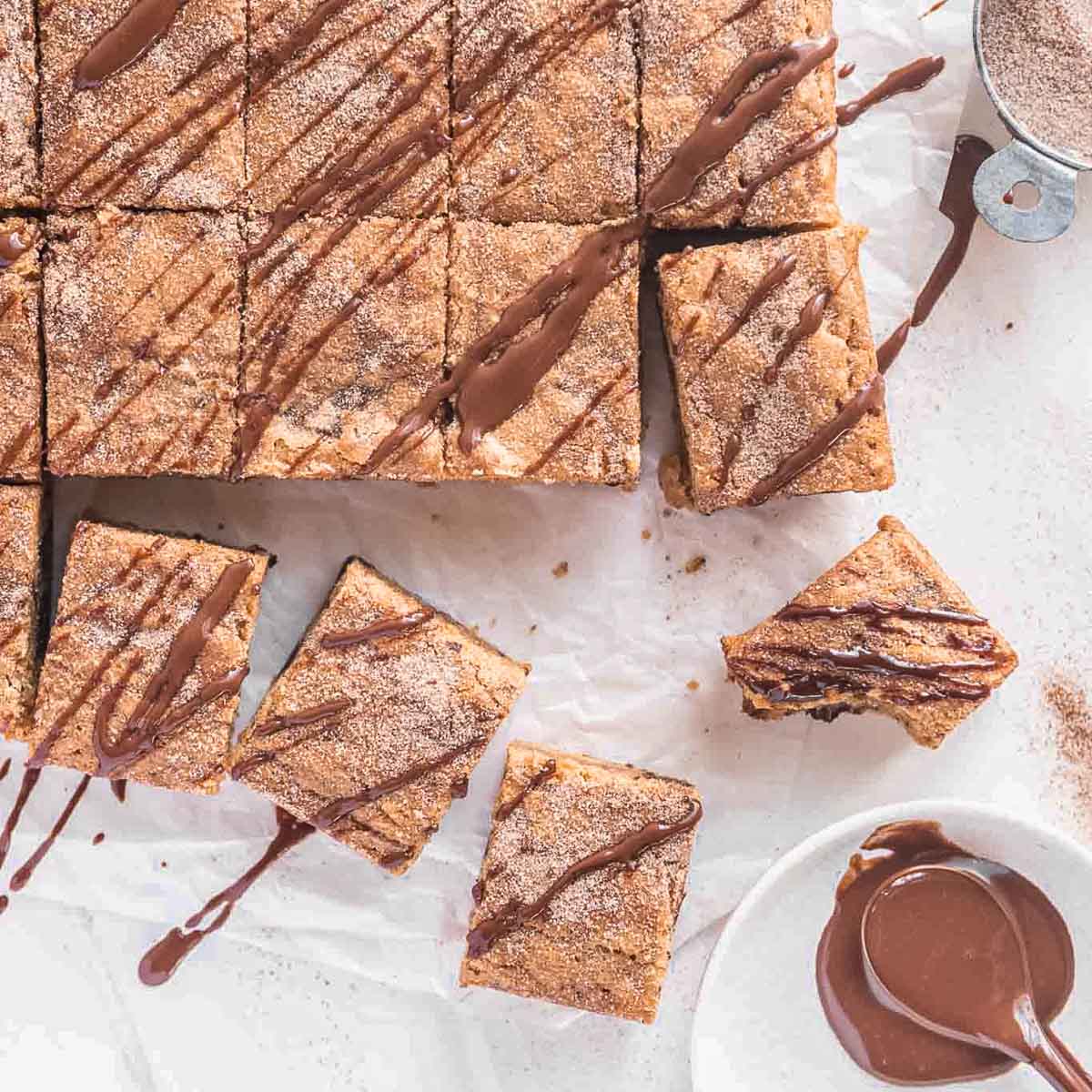 Churro blondies, drizzled with chocolate sauce.
