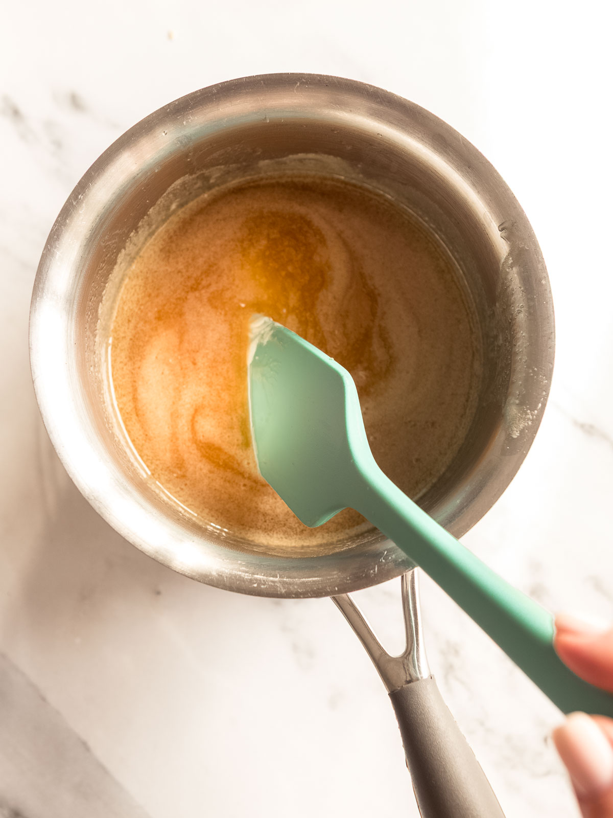 Melting the butter and honey to make a honey joy slice.
