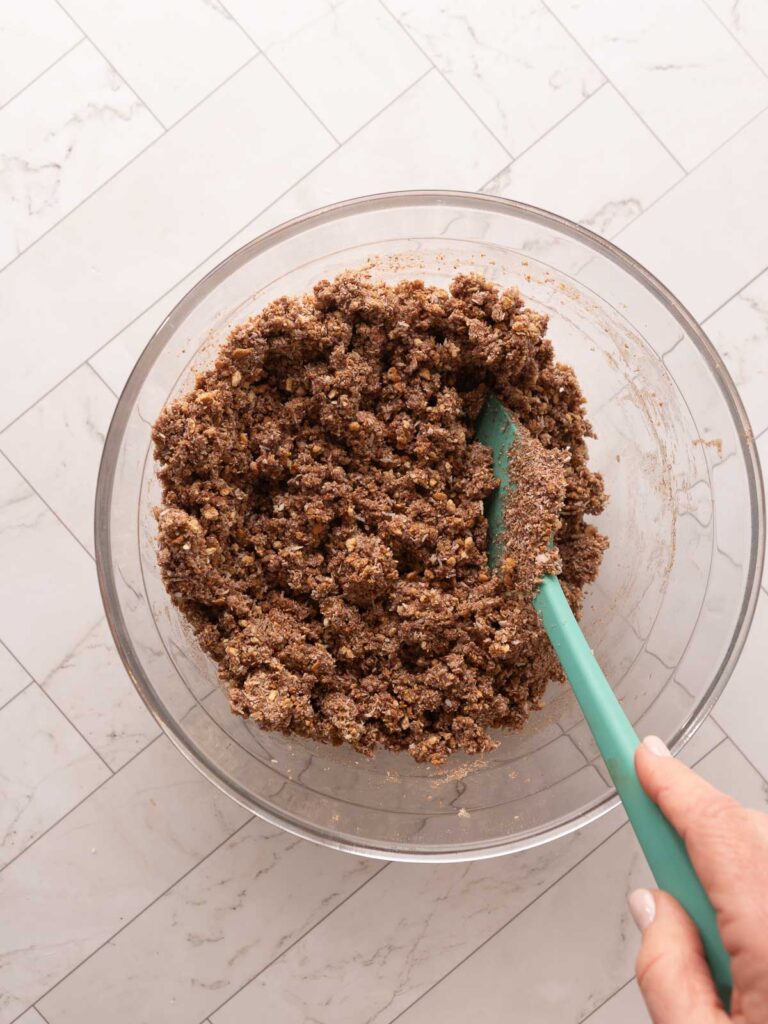 Combining condensed milk into the dry ingredients to make a no-bake peppermint slice.