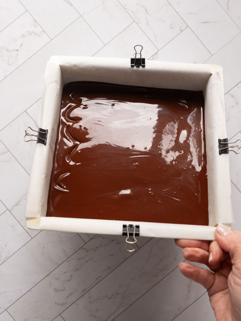 Melted chocolate and butter make the top of the no-bake peppermint slice -tilt the pan so the topping gets into the corners.