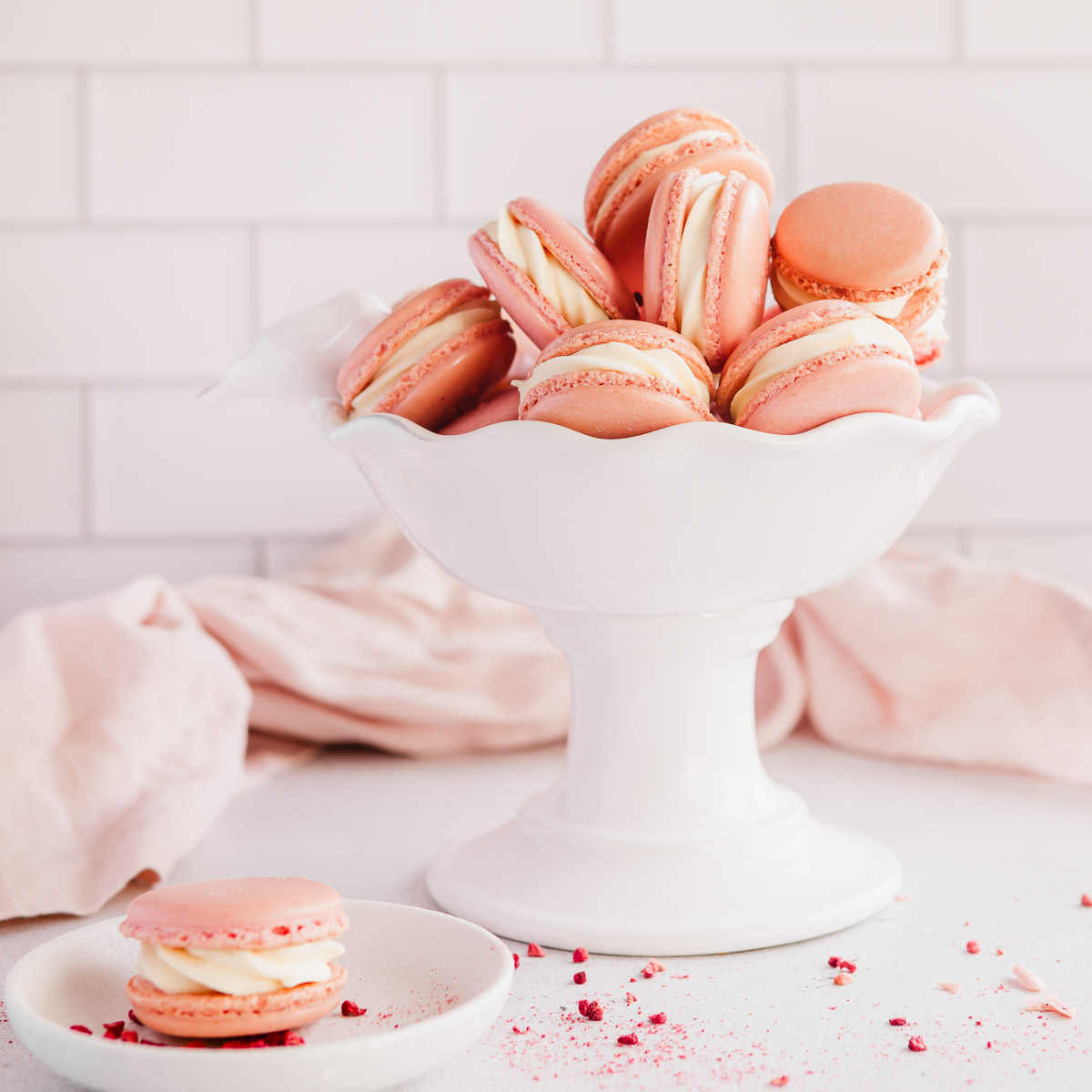 A bowl of pink raspberry macarons, filled with white chocolate ganache.