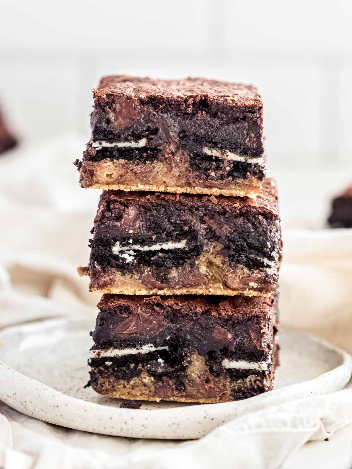 Squares of fudgy triple layer oreo brownies on a plate.