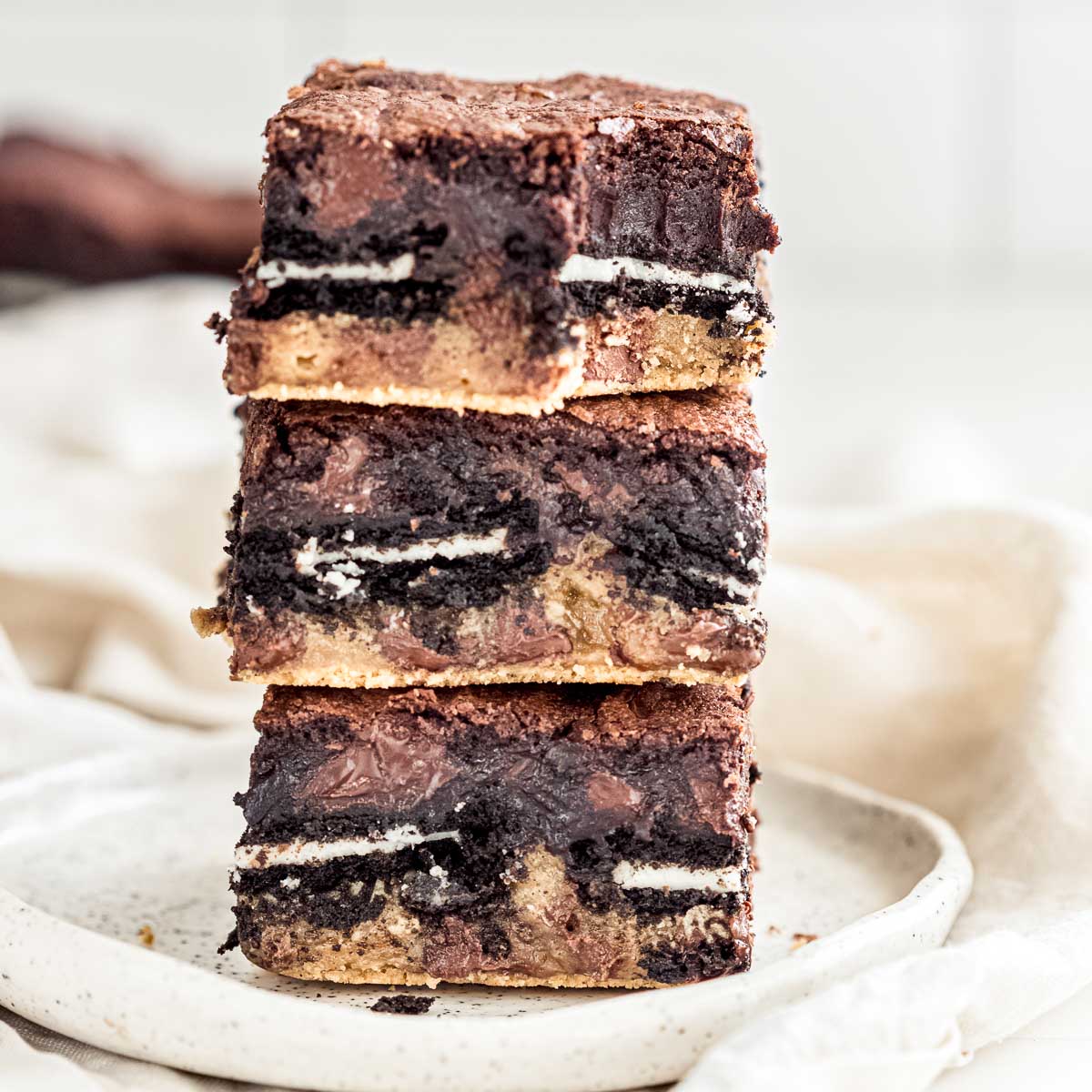 Three squares of triple layer brownies on a plate.
