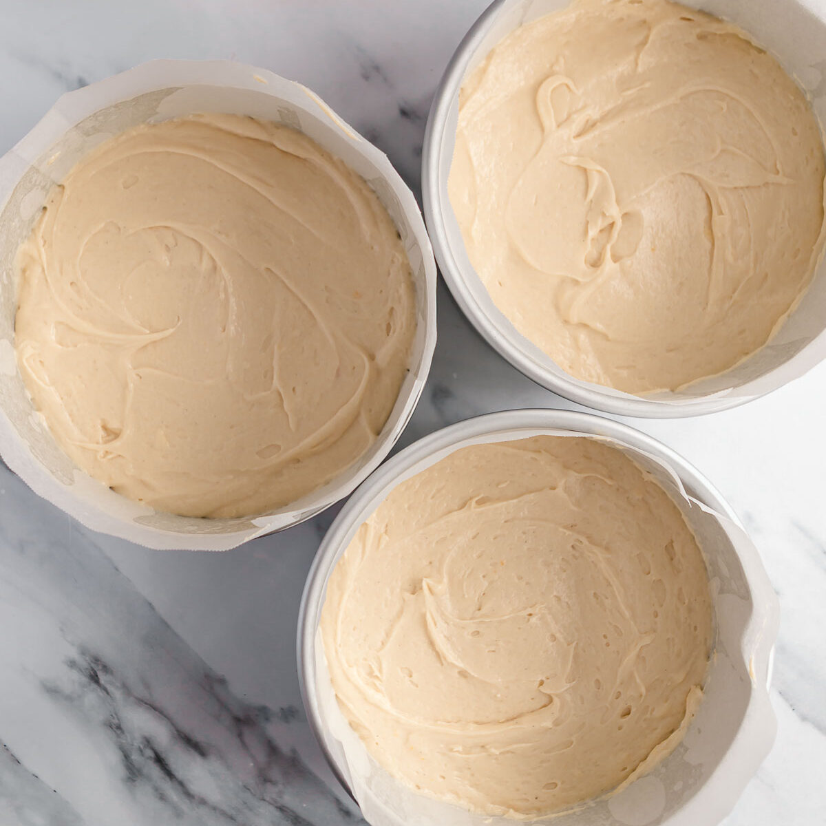 Making a 3 layer vanilla cake, by dividing the mixture into 3 cake pans.