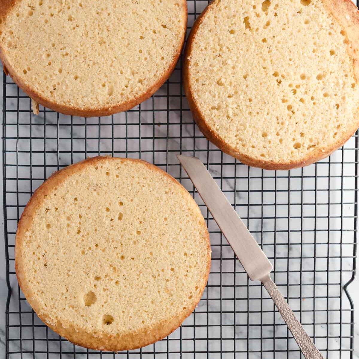 Making the cake layers even, by trimming the tops off the cakes.