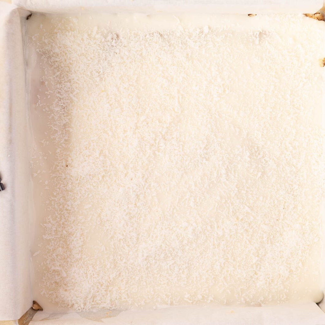 No bake lemon slice topped with lemon icing and coconut.
