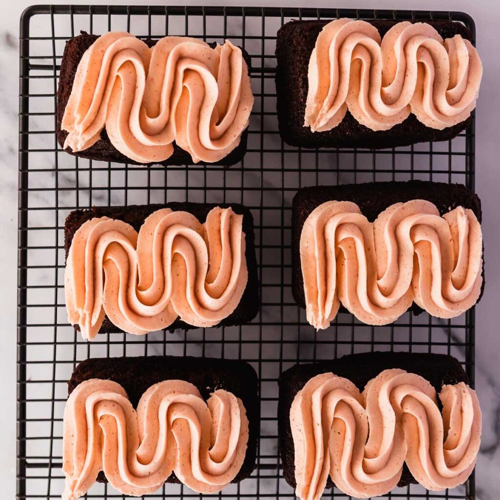 Pipe frosting onto cooled mini chocolate cakes.