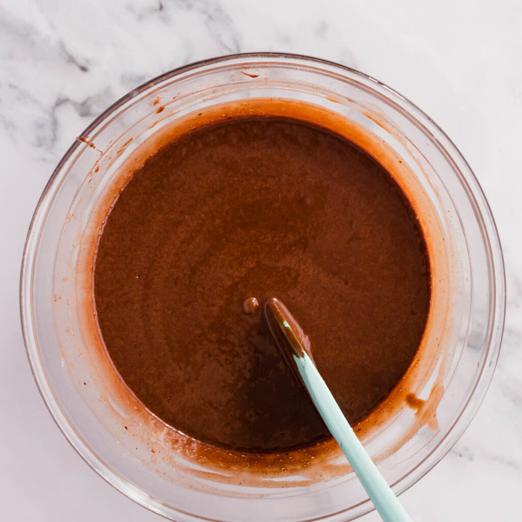 Combining the wet and ry ingredients to make mini chocolate cakes.