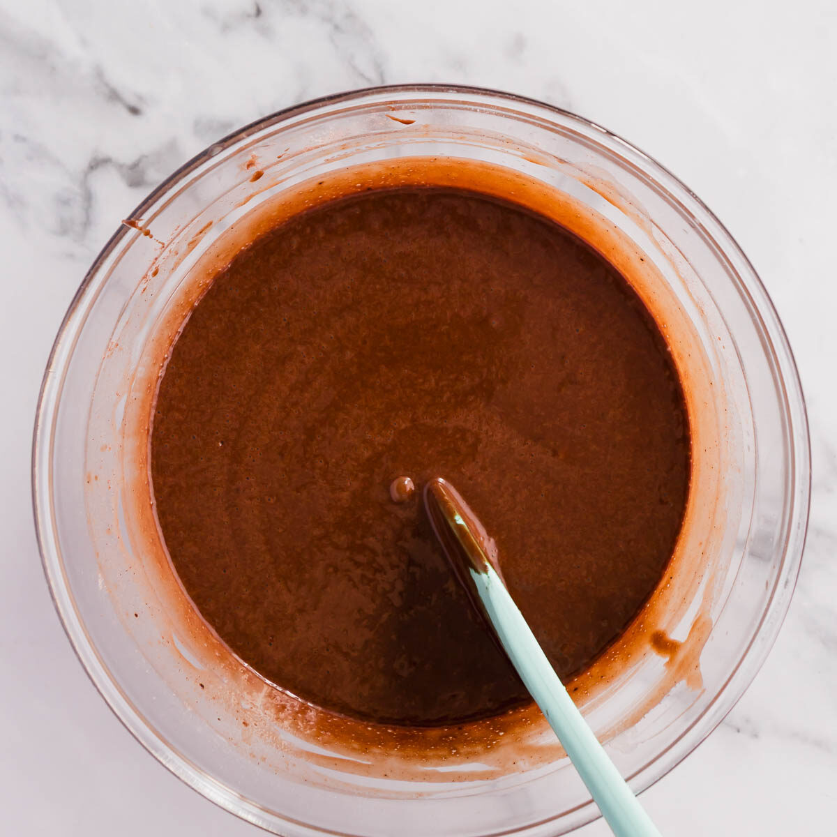 Combining the wet and ry ingredients to make mini chocolate cakes.